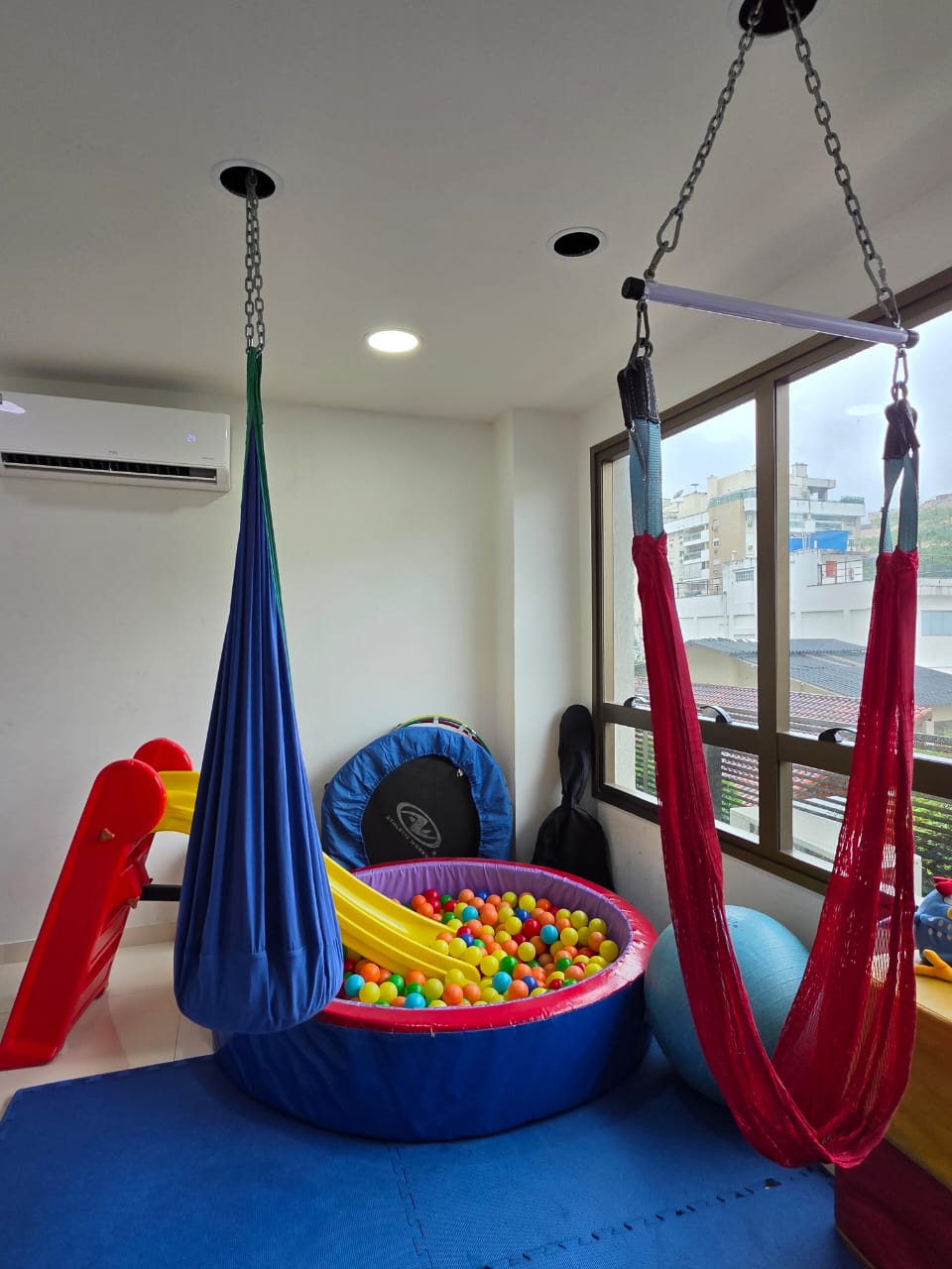 Sala de terapia da Conv!vi com piscina de bolinhas, balanços, escorregador e rede